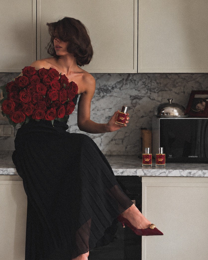 mujer con vestido negro y rosas rojas sosteniendo La Irresistible